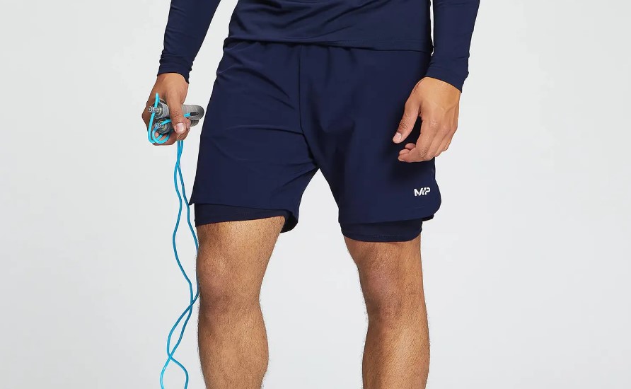 Lower torso of a man holding a skipping rope and wearing lined 7-inch shorts