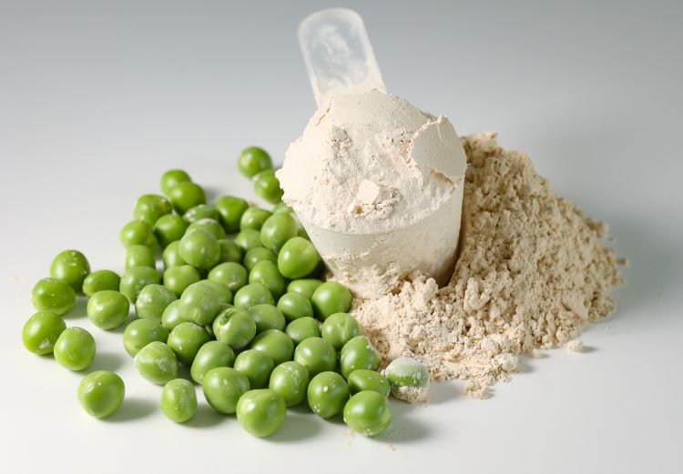 Protein powder, plastic scoop and fresh peas