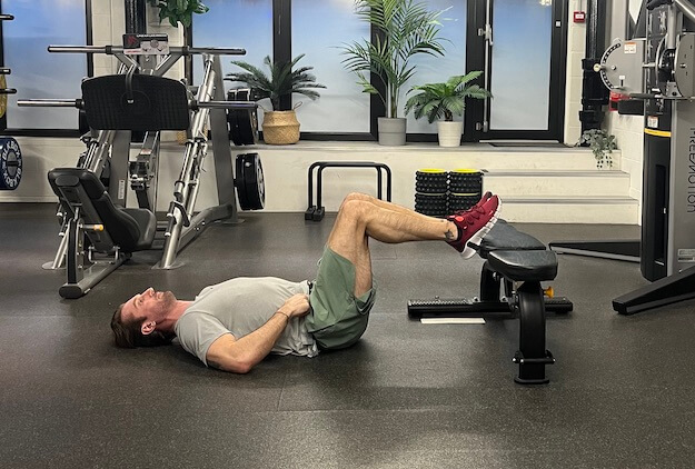 Man performing frogger exercise in gym