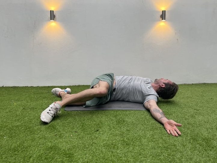 man demonstrates how to do side lying windmill, one of the best stretches for beginners