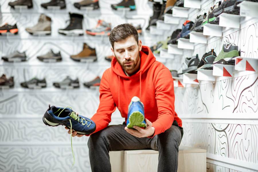 Man choosing running shoe in shop