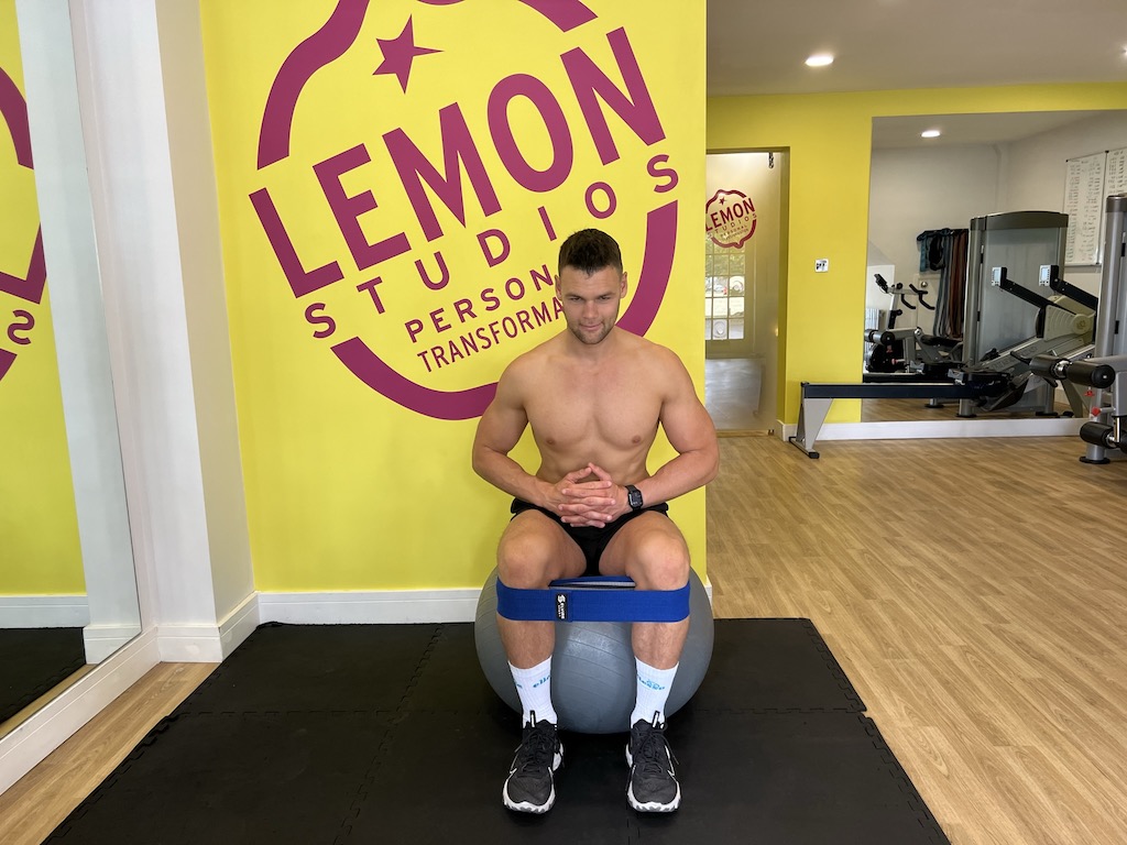 Man performing seated glute band abduction 
