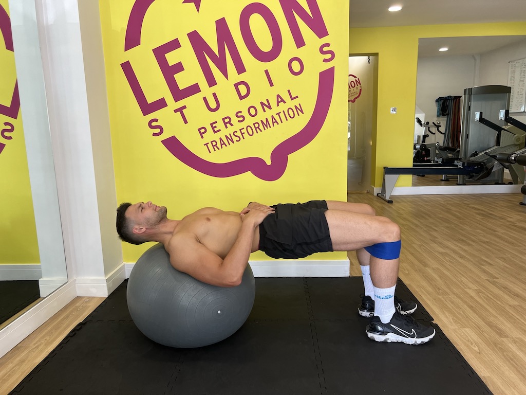 Man performing banded exercise ball hip thrust