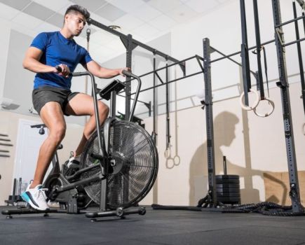 Man exercising on an air bike in a gym