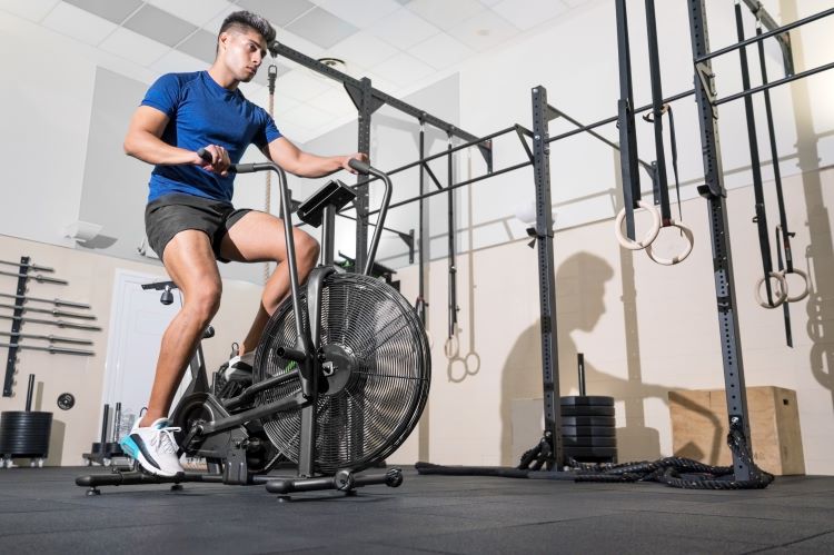 Man exercising on an air bike in a gym