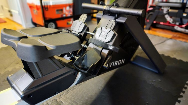 Close-up of the seat and foot straps of an Aviron Strong Series rowing machine