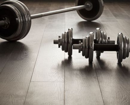 Dumbbells and a barbell on a wooden floor