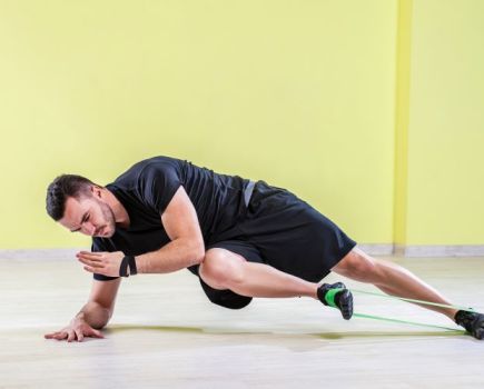 Man exercising legs with a resistance band
