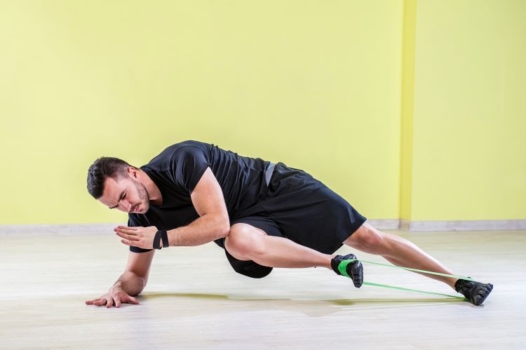 Man exercising legs with a resistance band