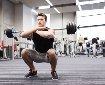 Man in a gym performing a barbell squat