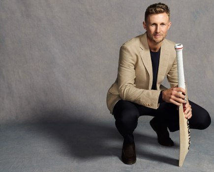 England cricketer Joe Root wears Charles Tyrwhitt jacket and squats down with cricket bat in hand