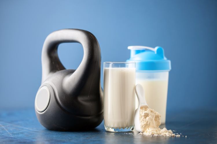 A kettlebell, shaker and glass of protein shake