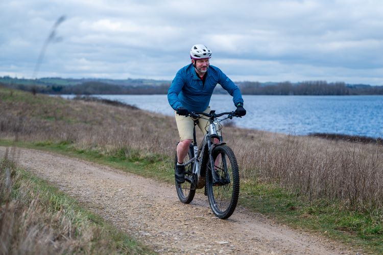 A man riding an e-bike by a lake