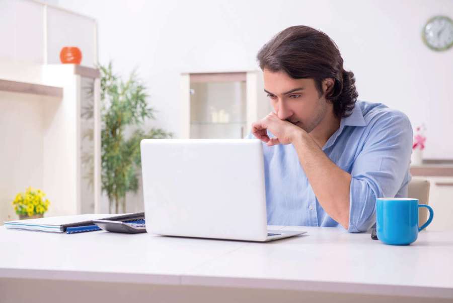 man trying to focus on his laptop at work