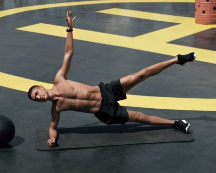 Man in a gym performing a star side plank