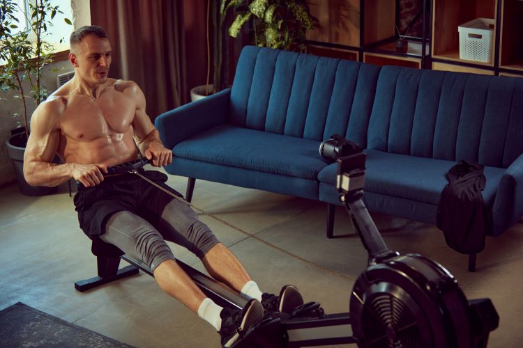 A man using a rowing machine in his living room