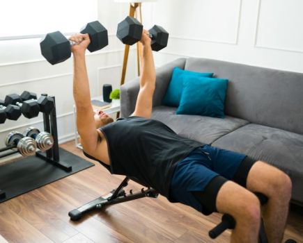 A man working out on an exercise bench at home