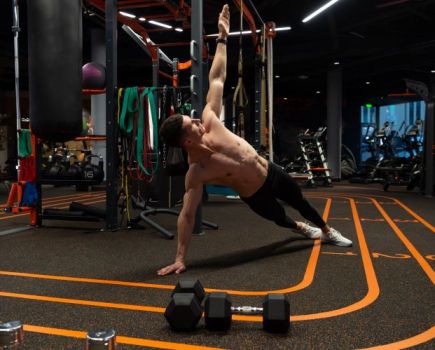 Man in a gym performing a side plank