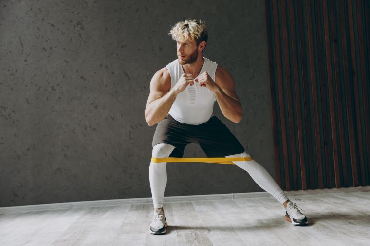 Man exercising legs with resistance band