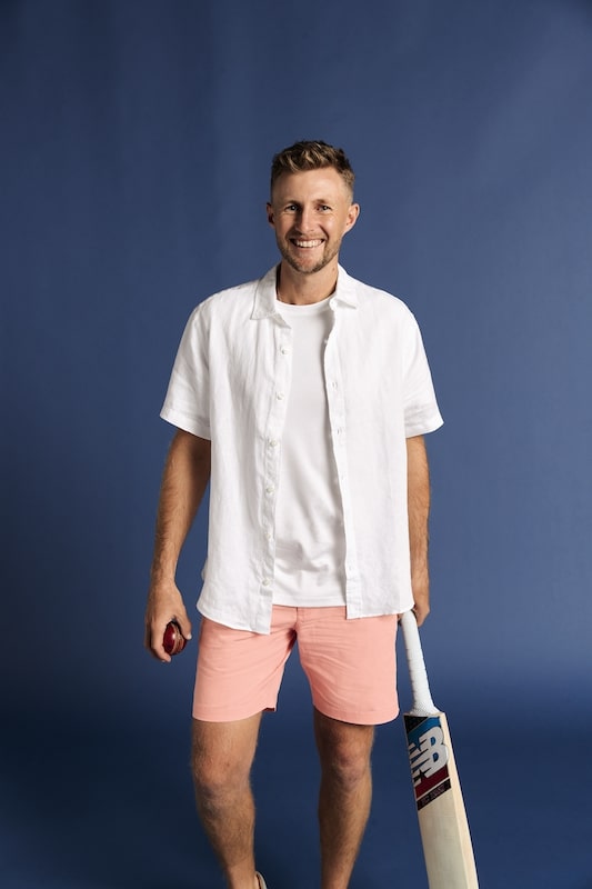 Joe Root poses in short-sleeved shirt and pink shorts