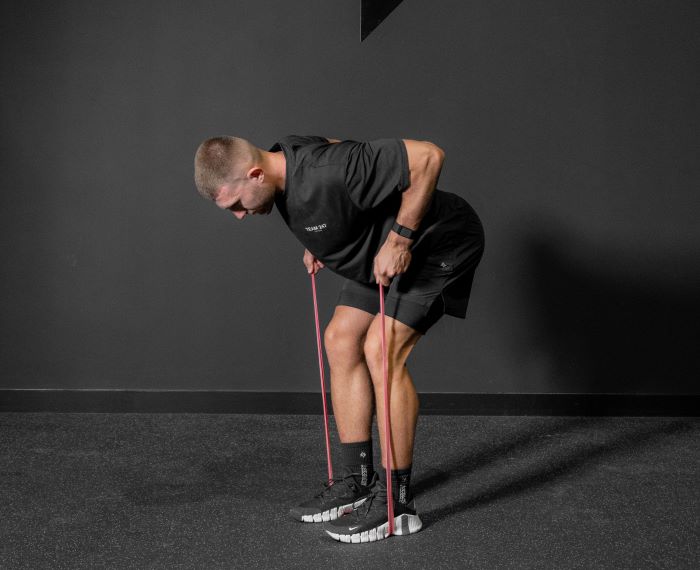 Man performing a resistance band bent over row