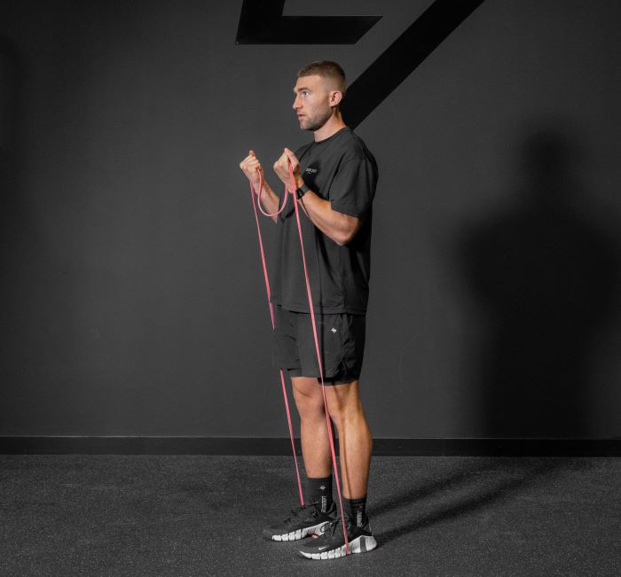 Man performing a resistance band biceps curl