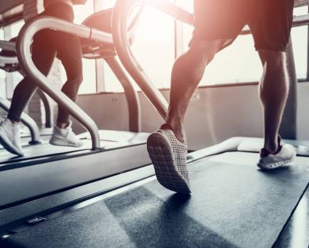 lower half of man running on treadmill in gym