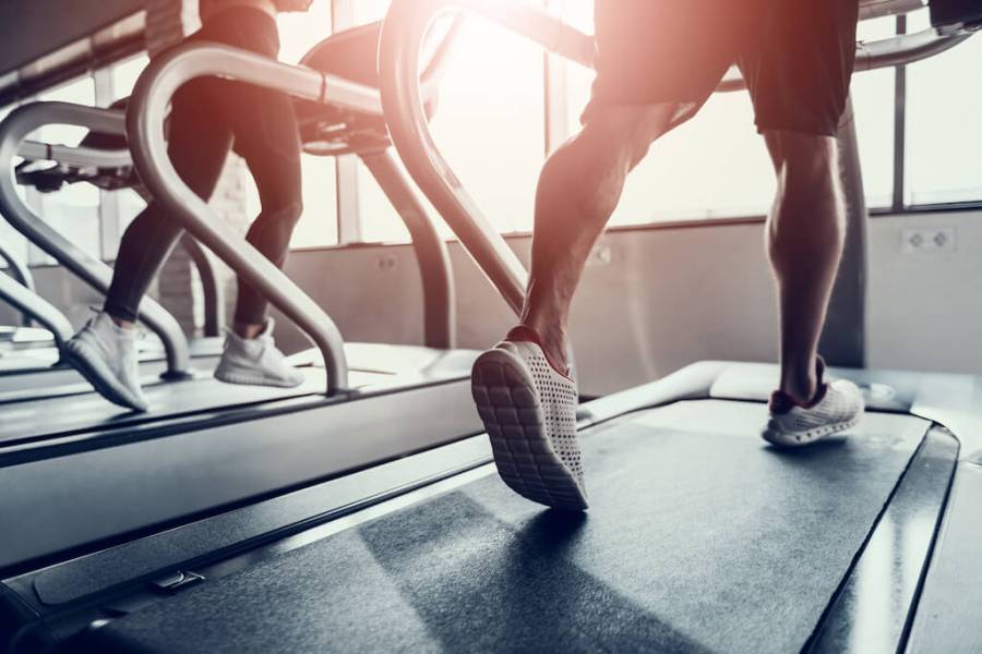 lower half of man running on treadmill in gym