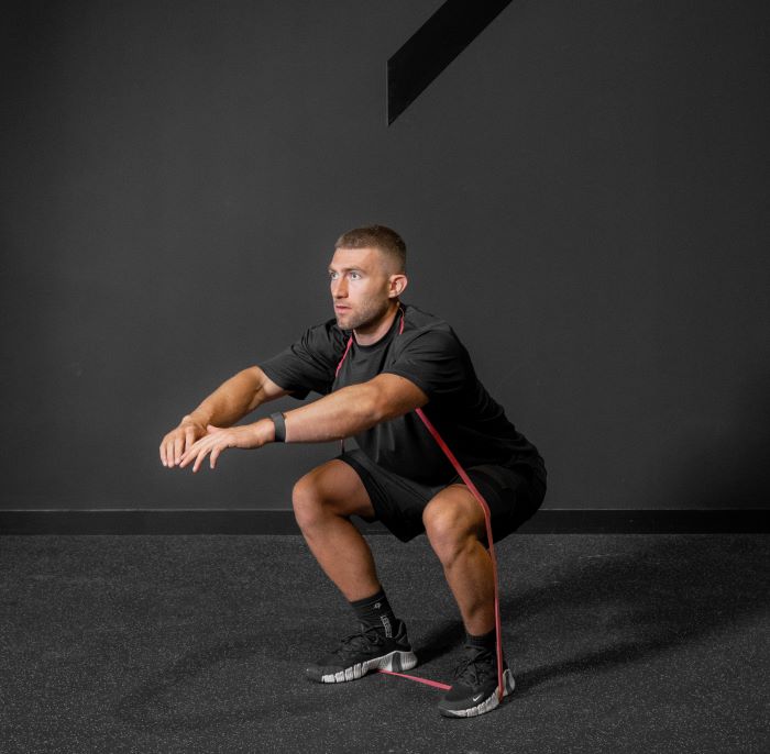 Man performing a resistance band squat
