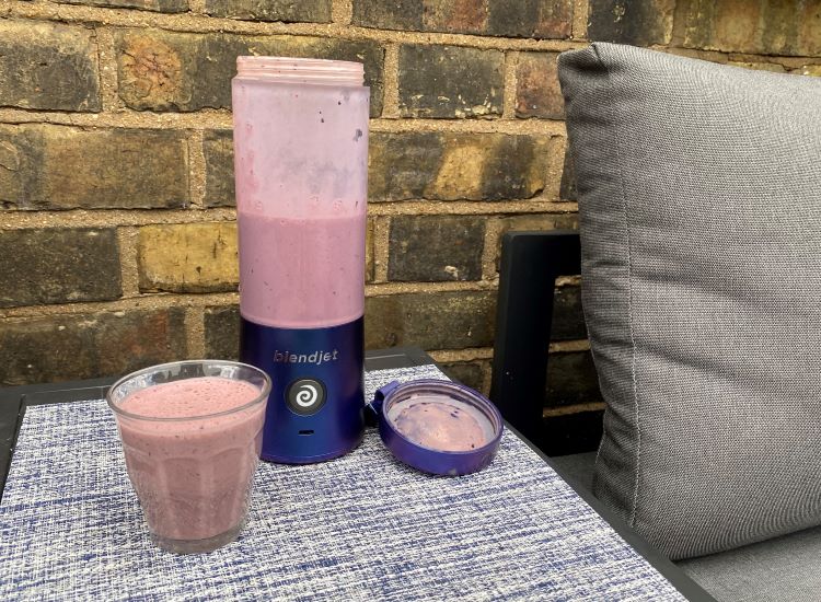 BlendJet2 blender and smoothie on an outside table
