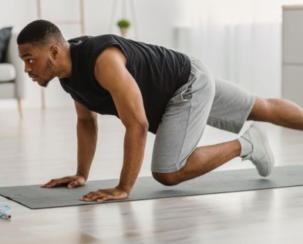 Man on a gym mat doing plank variations