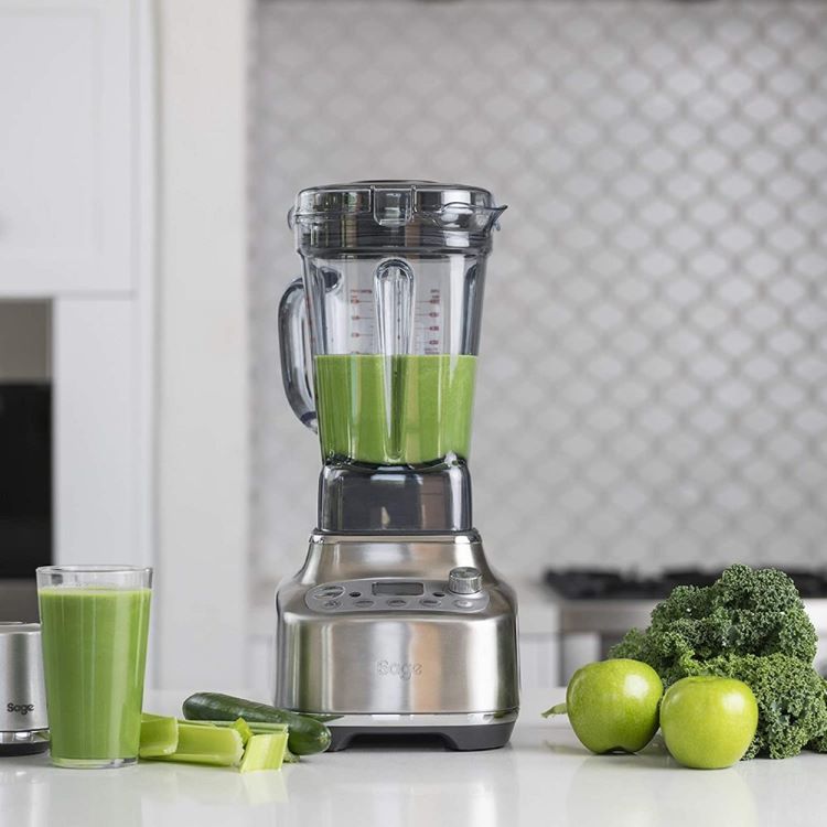 A Sage The Super Q blenders in a kitchen with a green smoothie inside