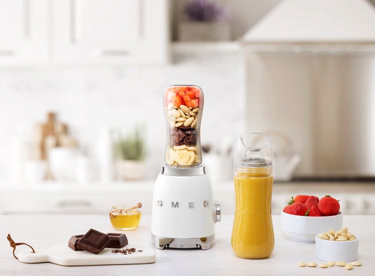 A Smeg blender with food and accessories on a kitchen worktop