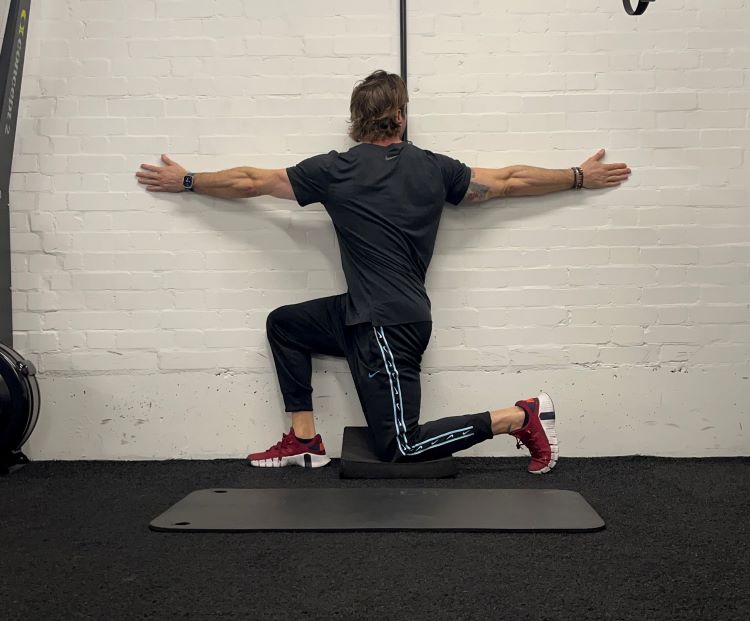 Man performing half kneeling windmill - best back stretches