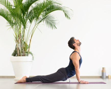 man performing yoga stretch cobra at home