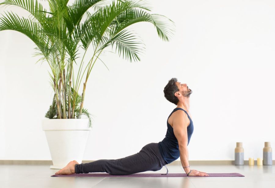 man performing yoga stretch cobra at home