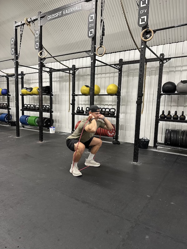 man performing band thruster exercise