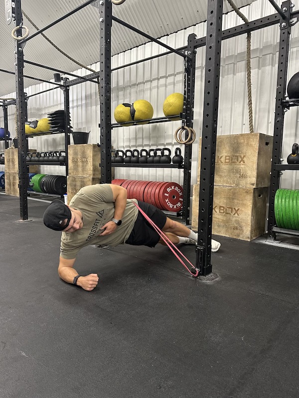 man performing band side plank raise