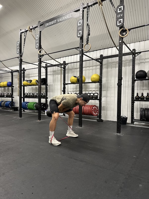 man performing band kettlebell swing exercise