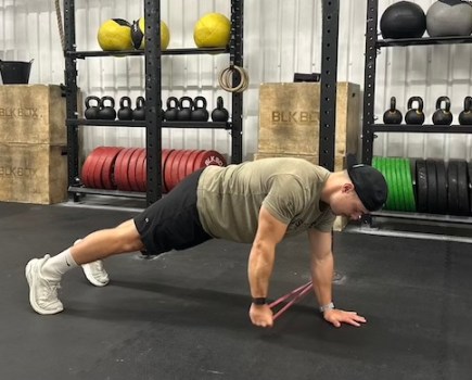 man in gym performing banded abs exercise