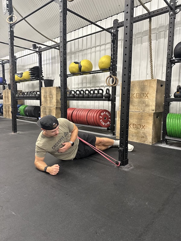 man demonstrating band side plank raise core exercise
