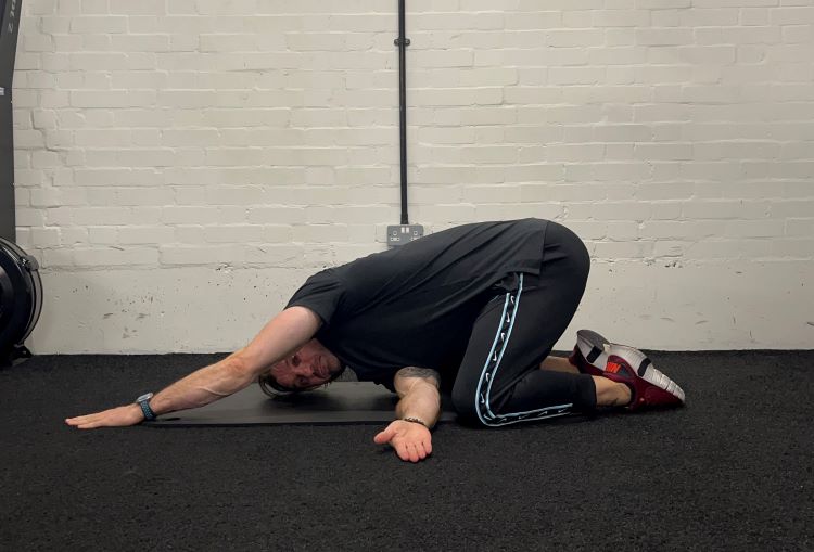 Man performing thread the needle - best back stretches
