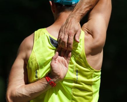 A man stretching shoulders and touching hands behind his back