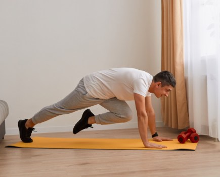 man performing abs exercises at home in sweatpants