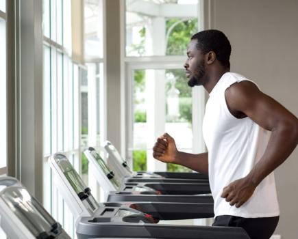 man running on treadmill for fitness and health benefits