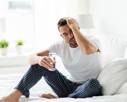 man with hangover in morning drinking electrolyte drinks