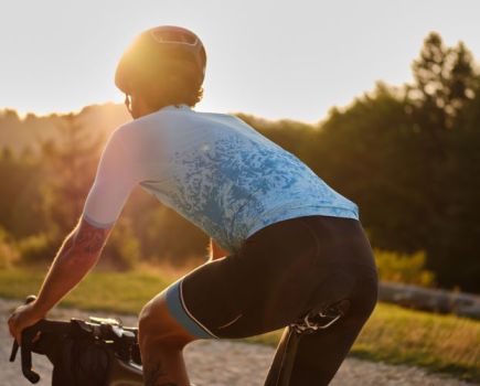 Man in cycling shorts riding at sunset