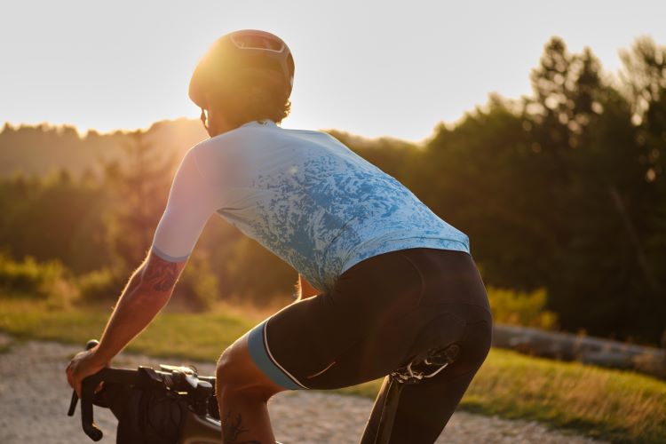 Man in cycling shorts riding at sunset