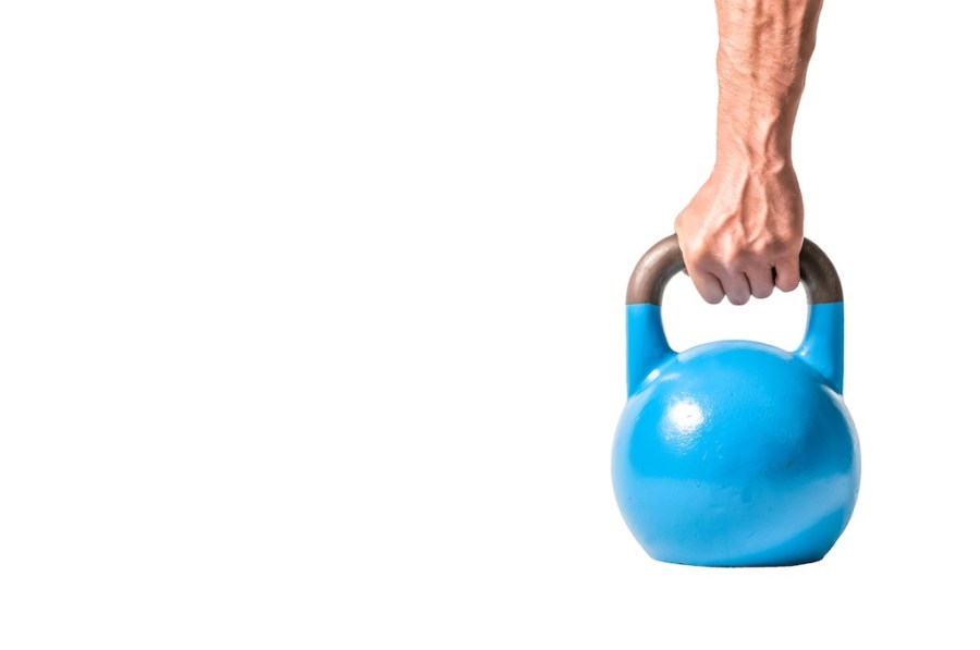 man's hand gripping the handle of a blue kettlebell