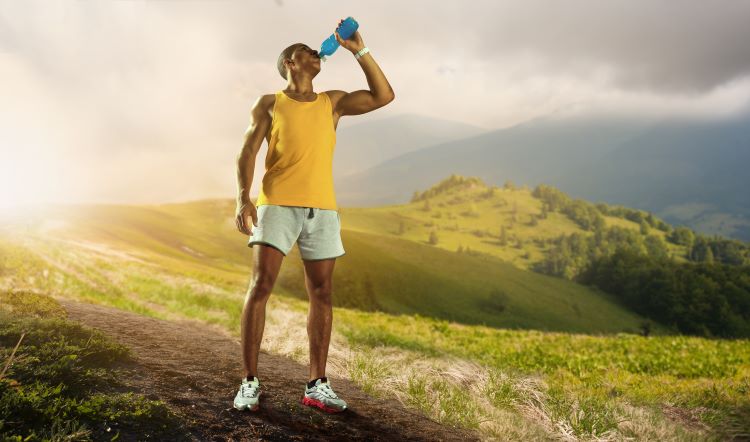 Male runner on a hill, drink a sports drink